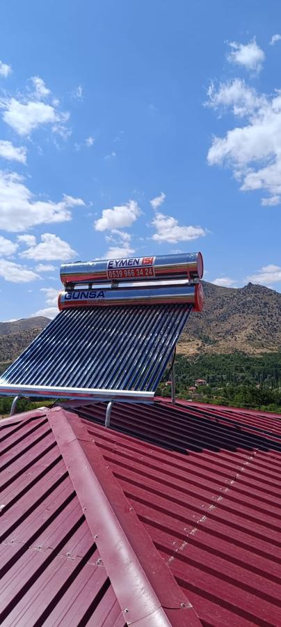Kırsalda kiremit rengi sac çatıya kurulan vakum tüplü güneş enerjisi sistemi